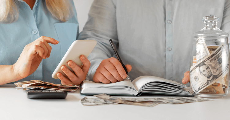 Pareja planificando finanzas con calculadora y dispositivos